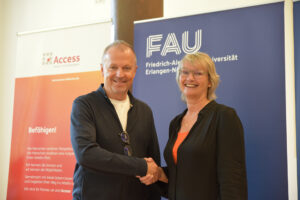 Andreas Hirsch von der FAU und Andrea Seeger reichen sich die Hand.