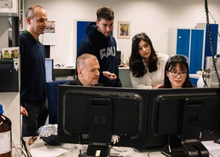 Menschen in Labor der Friedrich-Alexander-Universität Erlangen-Nürnberg vor Computerbildschirmen