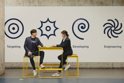 Ein Mann und eine Frau sitzen sich an einem Tisch gegenüber.