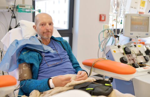Ein Mann sitzt im Krankenhaus mit einer Infusion im Arm.