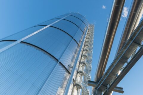 Ein Wärmespeicher. ein runder Turm aus Metall, aus der Froschperspektive fotografiert.