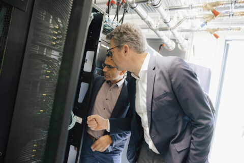 Wissenschaftsminister Markus Blume besucht das NHR@FAU und lässt sich von Direktor Gerhard Wellein (l.) den Superrechner HELMA erklären. (Bild: FAU/Giulia Iannicelli)