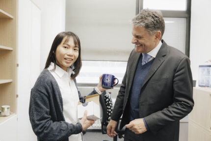 Prof. Ng mit der fAU Tasse in der Hand.