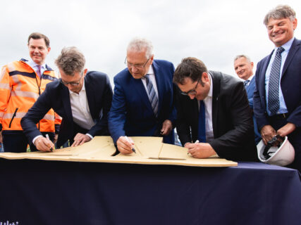 Vor Ort wurde symbolisch auf einer Induktionsspule unterschrieben. Auf dem Bild zu sehen (v.l.): Dr. Michael Güntner, Vorsitzender Autobahn GmbH des Bundes, Markus Blume, Bayerischer Wissenschaftsminister, Joachim Herrmann, Bayerischer Innenminister, Tobias Gotthardt, Staatssekretär im Bayerischen Wirtschaftsministerium und Prof. Dr. Joachim Hornegger, FAU-Präsident (Bild: wirdenkenlokal/Simon Rüger)