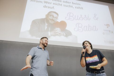 FAU-Wissenschaftskommunikatorin Laura Kneppe am Mikrofon begrüßt den Slammer vor Publikum