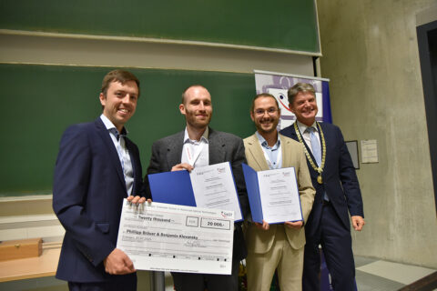 Die Gewinner des SAOT Innovation Awards, Benjamin Klevansky und Phillipp Bräuer, mit Dr. Max Gmelch (l.) von der SAOT und dem Präsidenten der FAU, Prof. Joachim Hornegger (r.).(Bild: FAU/Boris Mijat)